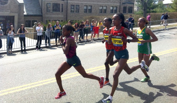 The women's leaders, including eventual winner Rita Jeptoo, fly past us at mile 21 of the 2014 Boston Marathon. By Tovin Lapan